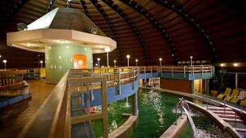 An indoor swimming pool with a central viewing area and multiple levels.