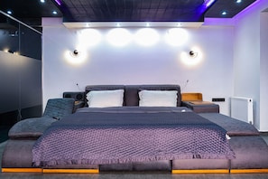 Un dormitorio moderno con una cama grande, mesitas de noche e iluminación empotrada.