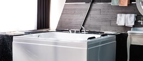 Une salle de bain moderne avec une grande baignoire, un mur en bois et un miroir.