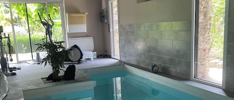 A swimming pool with a clear view of the surrounding area, including a door, a window, and a plant.