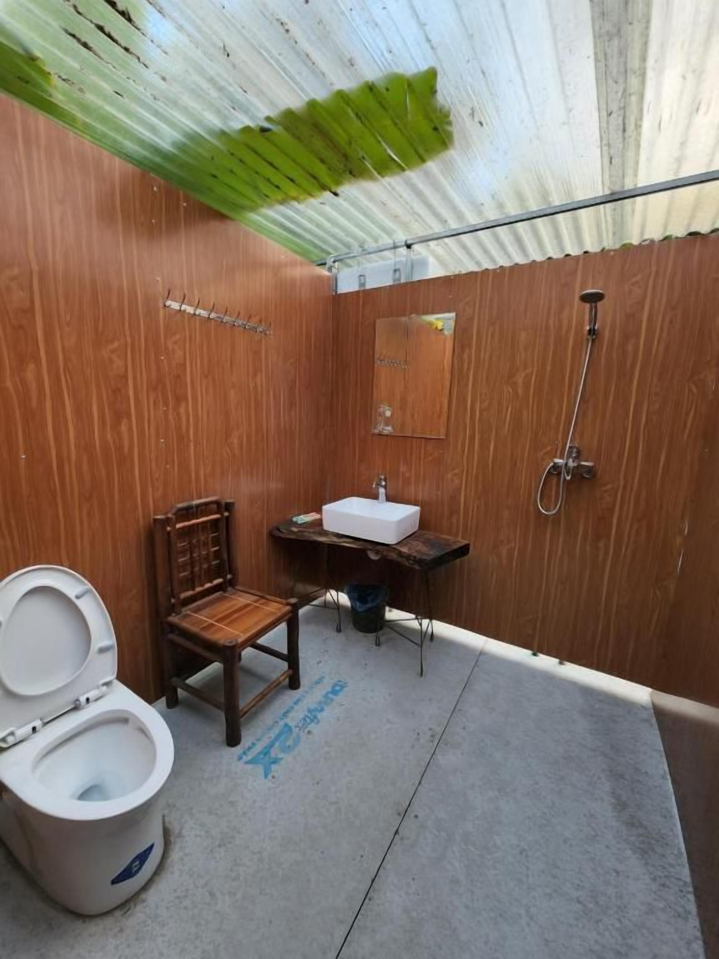 Un baño pequeño con tocador de madera, inodoro y ducha.