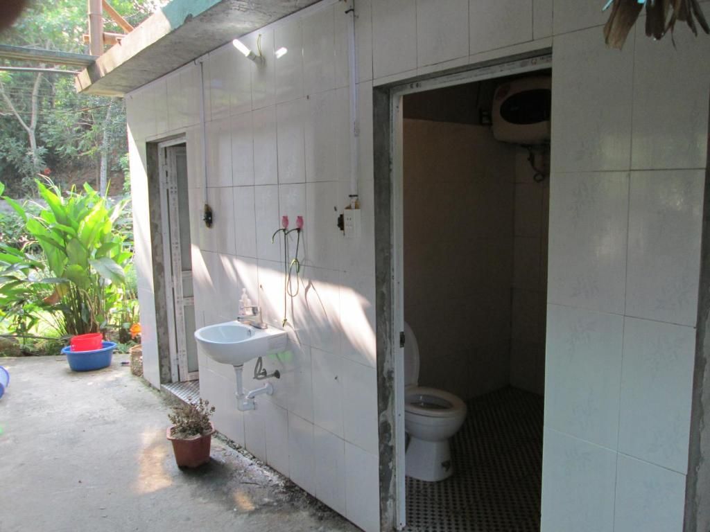 Ein Badezimmer mit weißem Waschbecken, WC und Duschbereich.