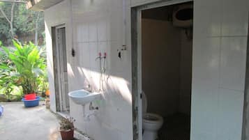 Ein Badezimmer mit weißem Waschbecken, WC und Duschbereich.