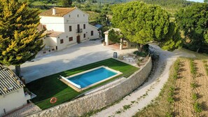 A villa with a swimming pool, surrounded by a stone wall and greenery. - Masía among vineyards with pool in Catalonia (El Pla de Manlleu)