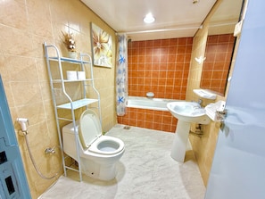 Une salle de bain comprenant des toilettes, une douche, une baignoire et un lavabo.