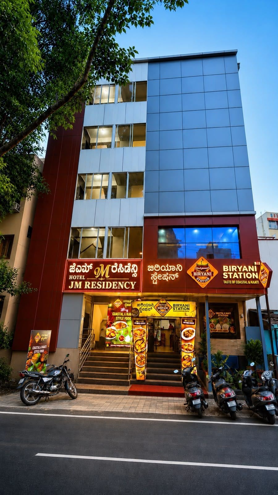 Ein Hotel mit mehreren Etagen, einer auffälligen Beschilderung für ein Restaurant und einigen abgestellten Motorrädern.