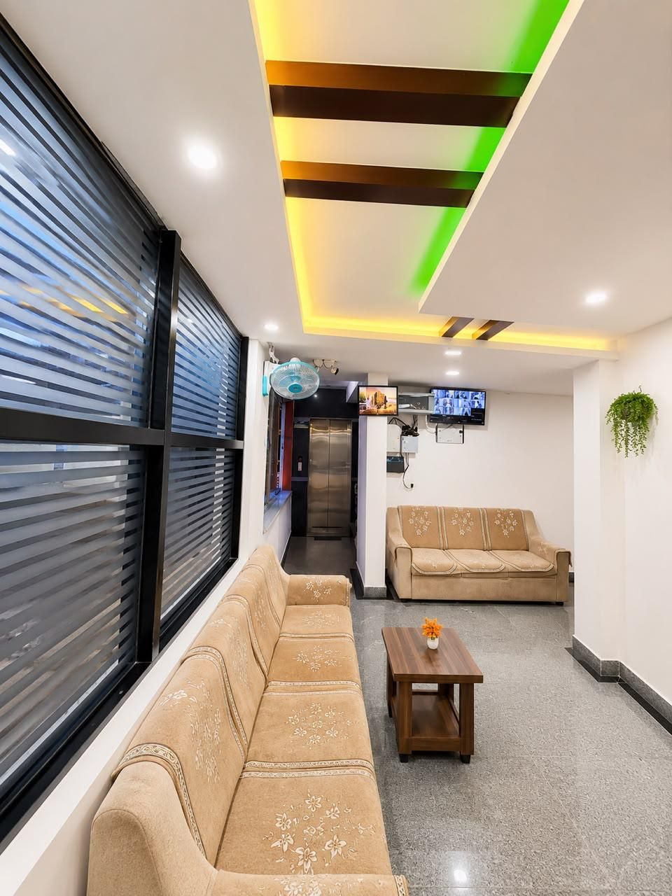 Un interior moderno con un sofá, una mesita y un televisor montado en la pared.