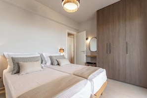 Une chambre avec deux lits, une armoire, un miroir et une lampe de chevet.