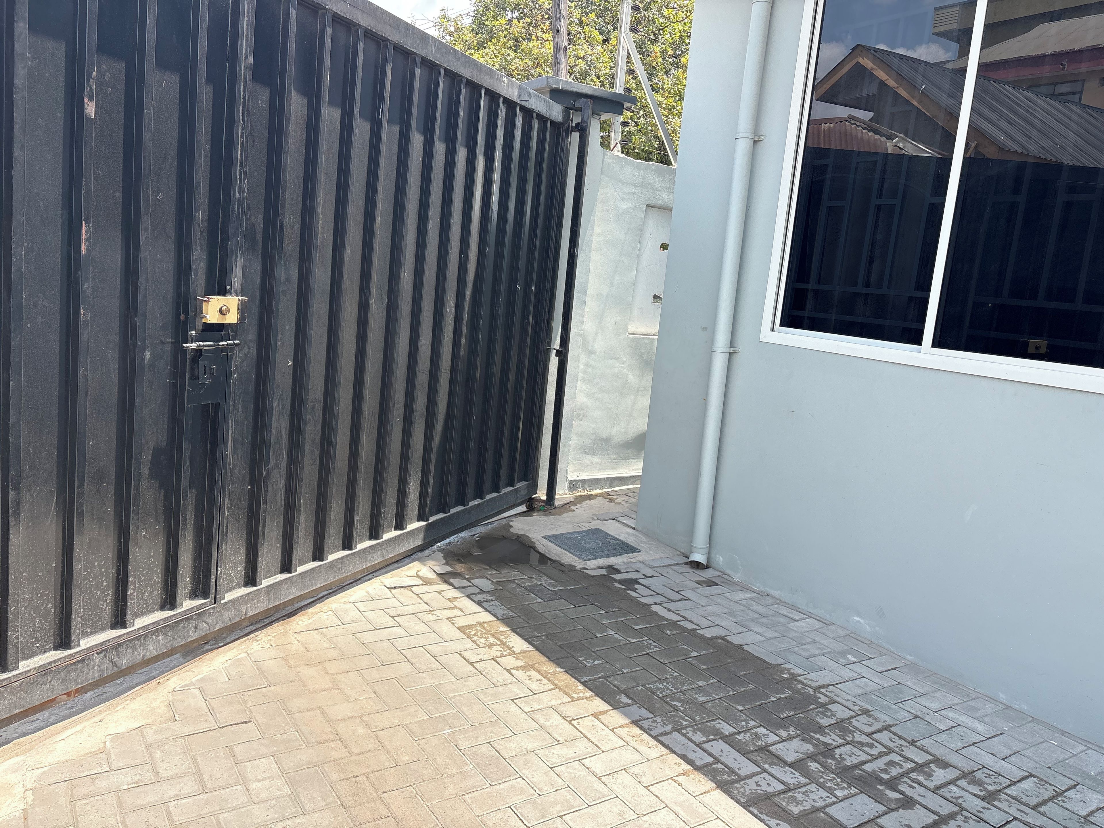 A gated area with a paved walkway leading to a building entrance.