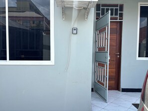 A building entrance with a white door, a window, and a metal gate.