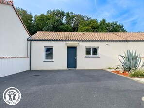 A building with a tiled roof, a dark door, and two windows. - Cottage, pets allowed - 4 guests (Saint-Révérend)