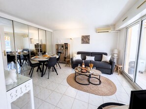 Ein modernes Wohnzimmer mit Essbereich, einer Couch und einem Couchtisch mit Speisen und Getränken.