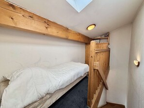 A small, compact room with a bunk bed, a skylight, and a wooden ladder. - Apartment with mountain view - 6 guests (Praz-sur-Arly)