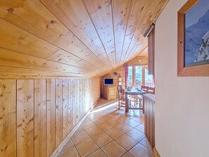 Ein Holzinterieur mit Essbereich, Fernseher und Fenster mit Aussicht.