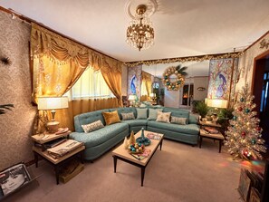 A cozy living room with a sectional sofa, a coffee table, and a Christmas tree.