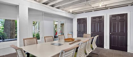 A conference room with a long table, chairs, and a ceiling with exposed beams.