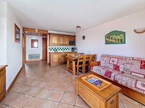 A compact living space with a kitchen, dining area, and a sofa. - Bright apartment near the slopes - 4 guests (Les Menuires)