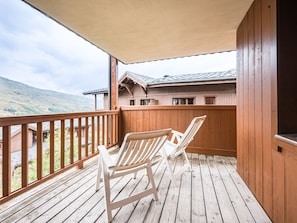 A wooden deck with two white chairs, overlooking a mountainous landscape. - Bright apartment near slopes (Les Menuires)