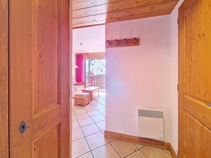 Ein Flur mit Holztäfelung führt zu einem Balkon mit Blick auf eine verschneite Landschaft.