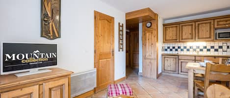 Una cocina moderna con armarios de madera, un microondas y un salpicadero de azulejos.