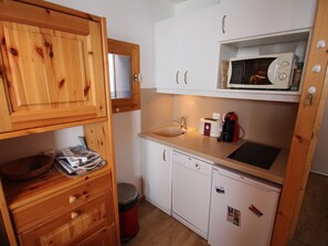 A compact kitchen with wooden cabinets, a microwave, a toaster, and a dishwasher. - Central studio, ski-in/ski-out - 3 guests (La Plagne Montalbert)