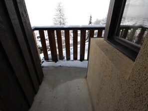 A balcony with a wooden railing and a view of a snowy landscape. - Central studio, ski-in/ski-out - 3 guests (La Plagne Montalbert)