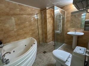 Un baño con bañera, inodoro, ducha y lavamanos.