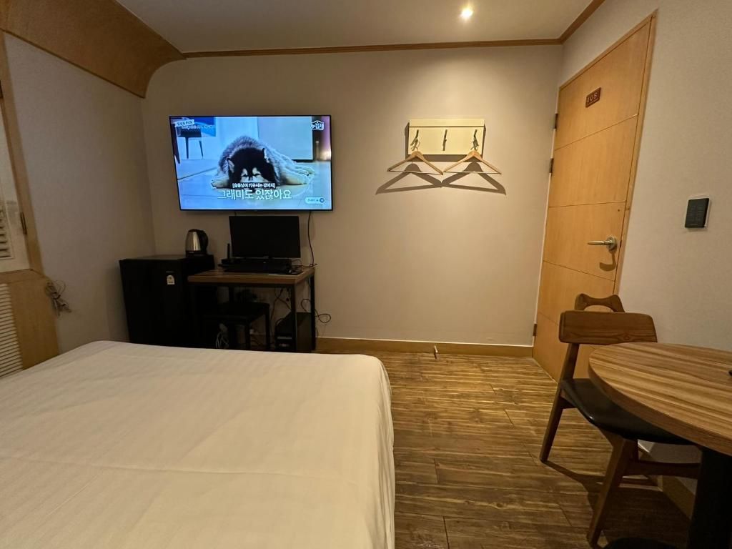 Une chambre d’hôtel comprenant un lit, une télévision, un bureau et une table à manger.