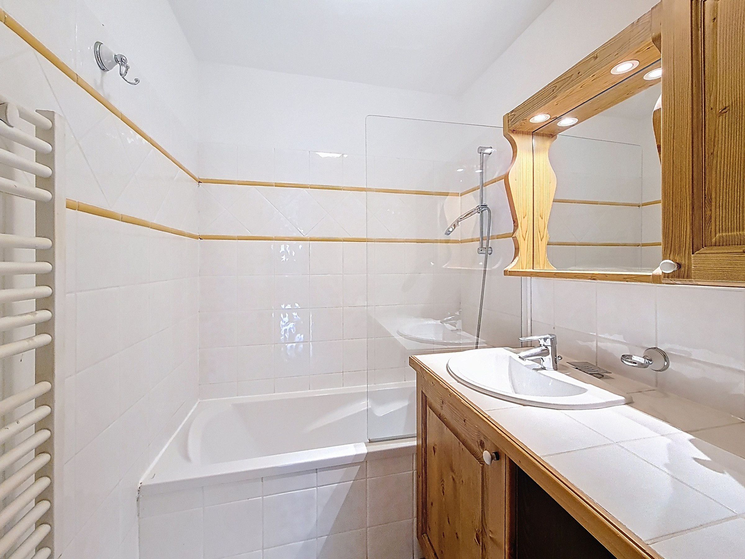 Ein modernes Badezimmer mit einer Badewanne, einem Waschbecken und einem Spiegel.