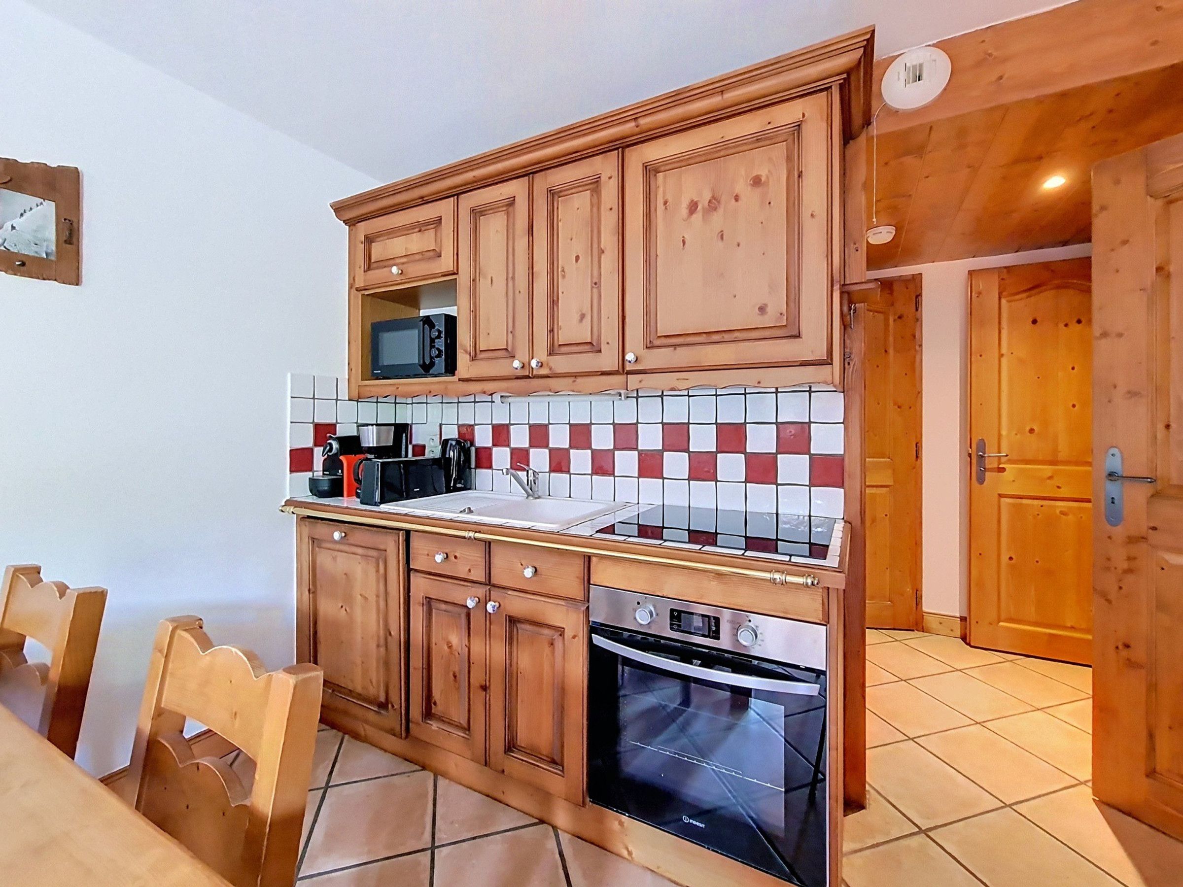 Una cocina con armarios de madera, un microondas, un tostador y un horno.