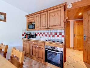 Eine Küche mit Holzschränken, einer Mikrowelle, einem Toaster und einem Backofen.