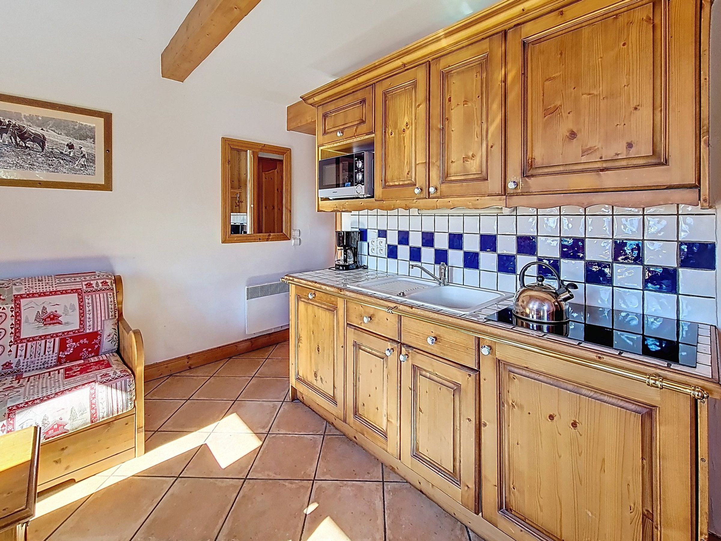 A kitchen with wooden cabinets, a microwave, and a tiled backsplash.