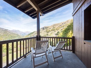 A wooden balcony with two chairs overlooking a mountainous landscape. - Spacious apartment near slopes - 6 guests (Les Menuires)