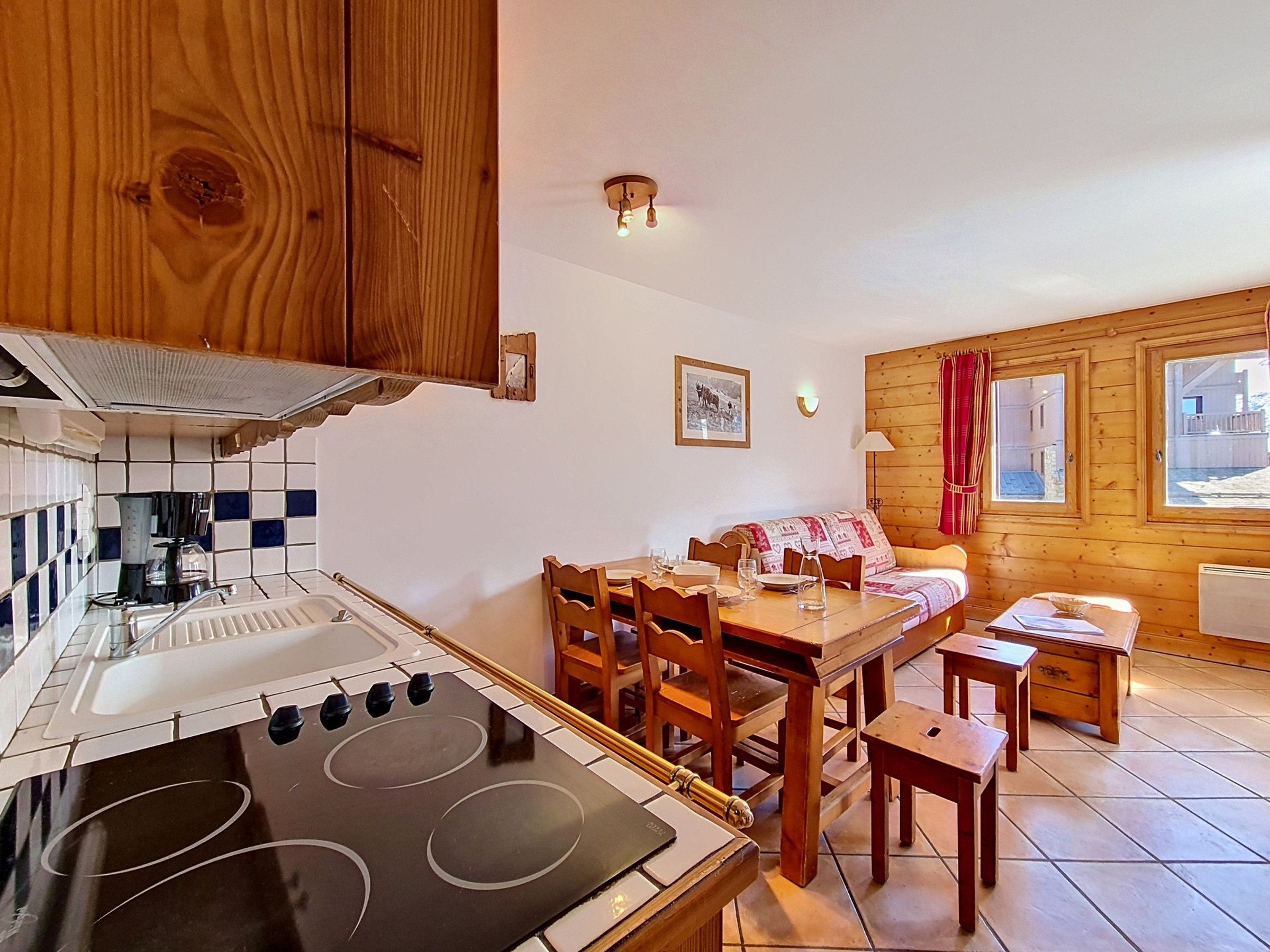A kitchen with a stove, wooden cabinets, and a dining area with a table and chairs.