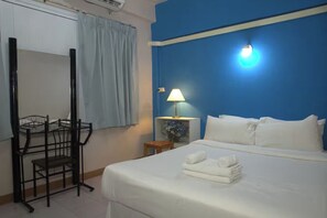 Une chambre d’hôtel avec un lit, un bureau et une chaise.