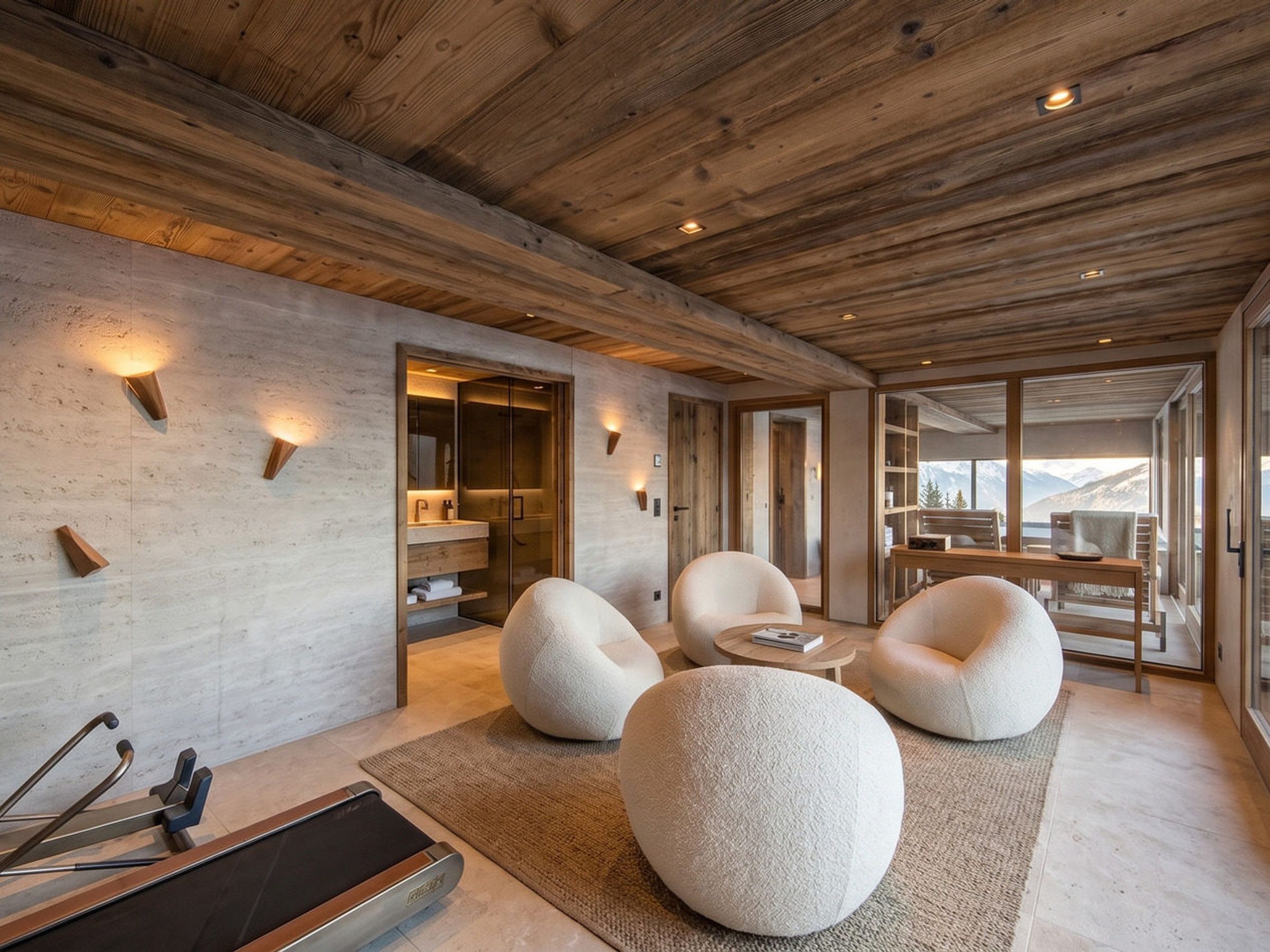 A modern interior with a wooden ceiling, a glass door leading to a balcony, and a seating area with round poufs.