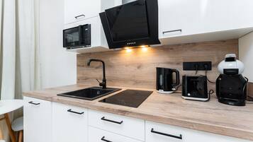 A modern kitchen with a sink, a microwave, a coffee maker, and a toaster.