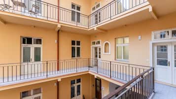 Ein mehrstöckiges Gebäude mit Balkonen, einer Treppe und einer Tür mit dem Buchstaben 'B'.