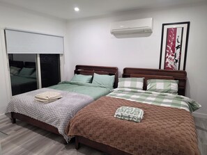 A bedroom with two beds, a window with blinds, an air conditioning unit, and a decorative wall piece. - Farm House - Yarra Valley (Woori Yallock)