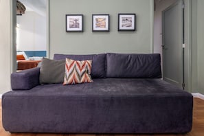 A grey sofa with patterned cushions in a room with light green walls. - 2 Quartos à 150m praia do Flamengo (Rio de Janeiro)