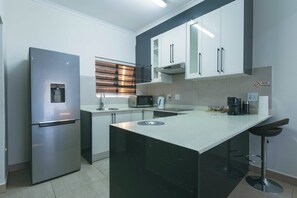 Una cocina moderna con refrigerador, microondas y cafetera incorporados.