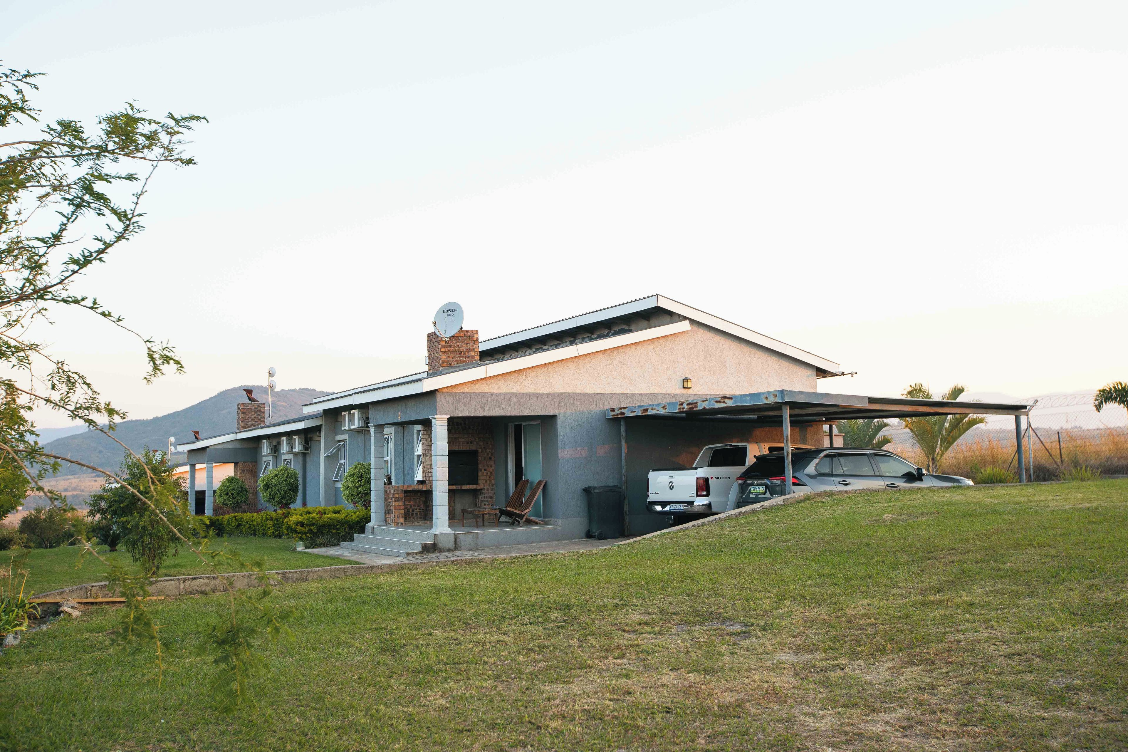 Une maison moderne dotée d’un patio couvert, d’une cheminée en briques et d’une antenne parabolique.