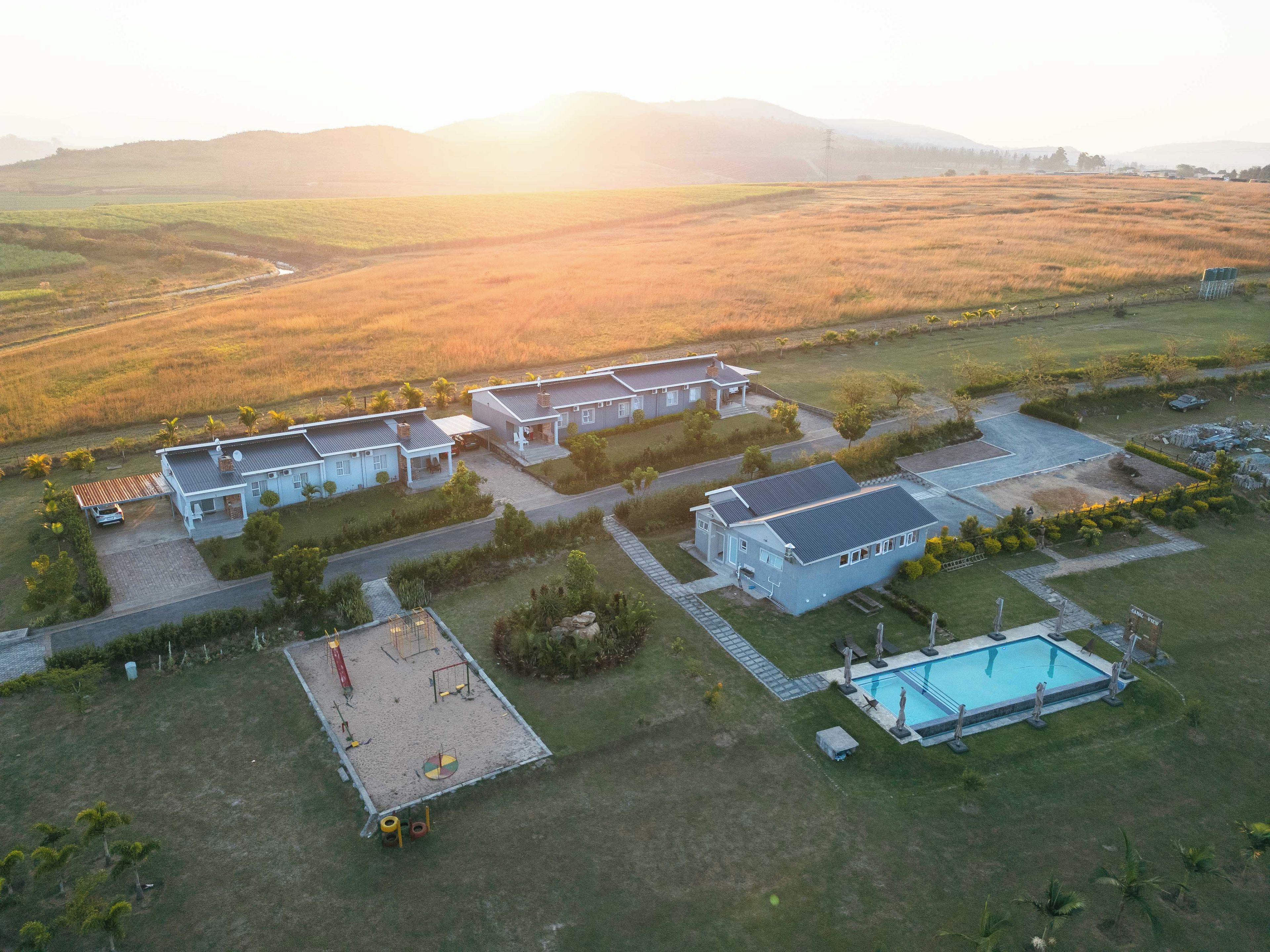 Zona residencial con casas, piscina y parque infantil.