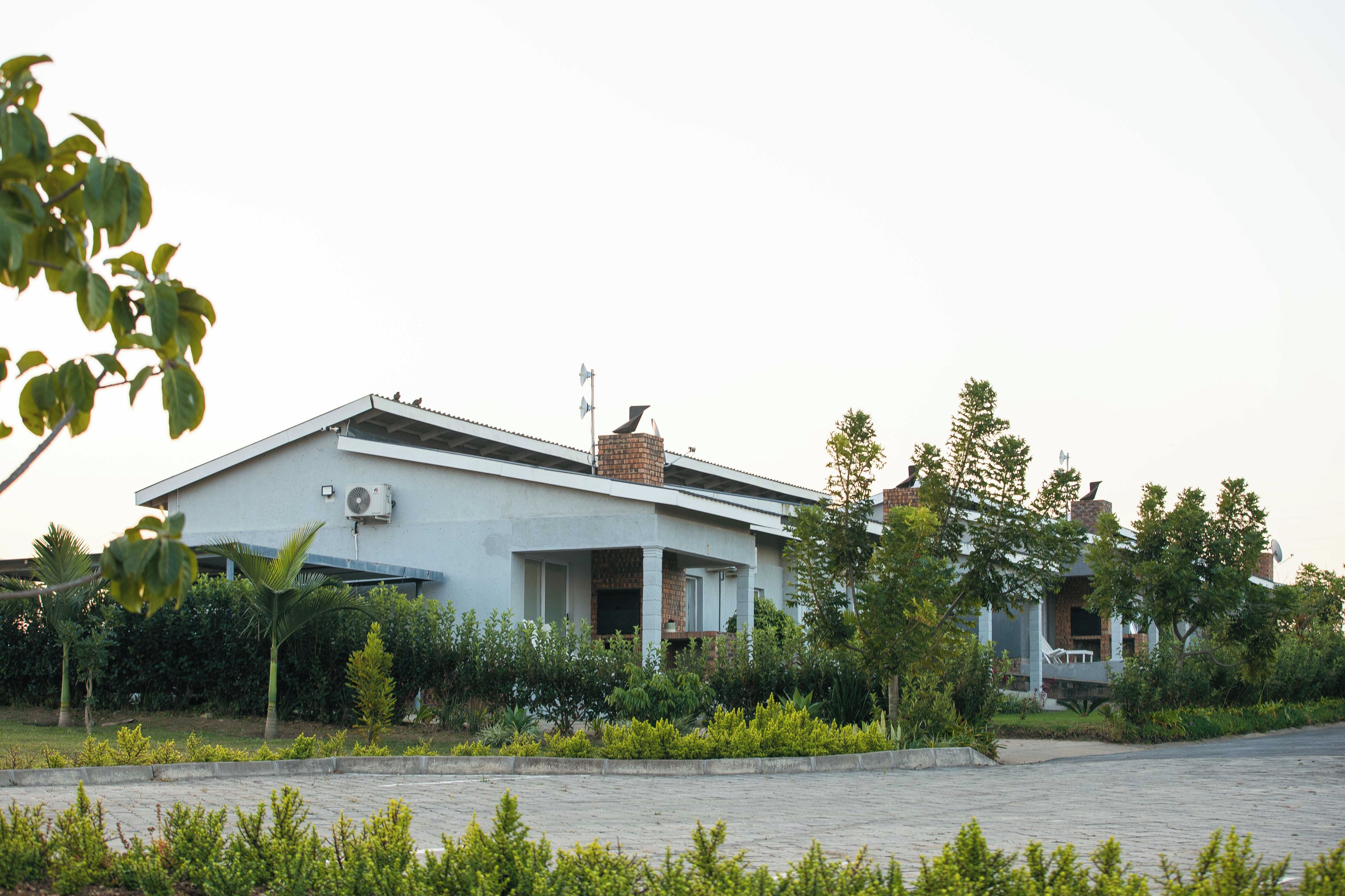 Una casa moderna de dos pisos con techo plano, antena parabólica y chimenea.