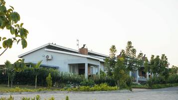 Una casa moderna de dos pisos con techo plano, antena parabólica y chimenea.