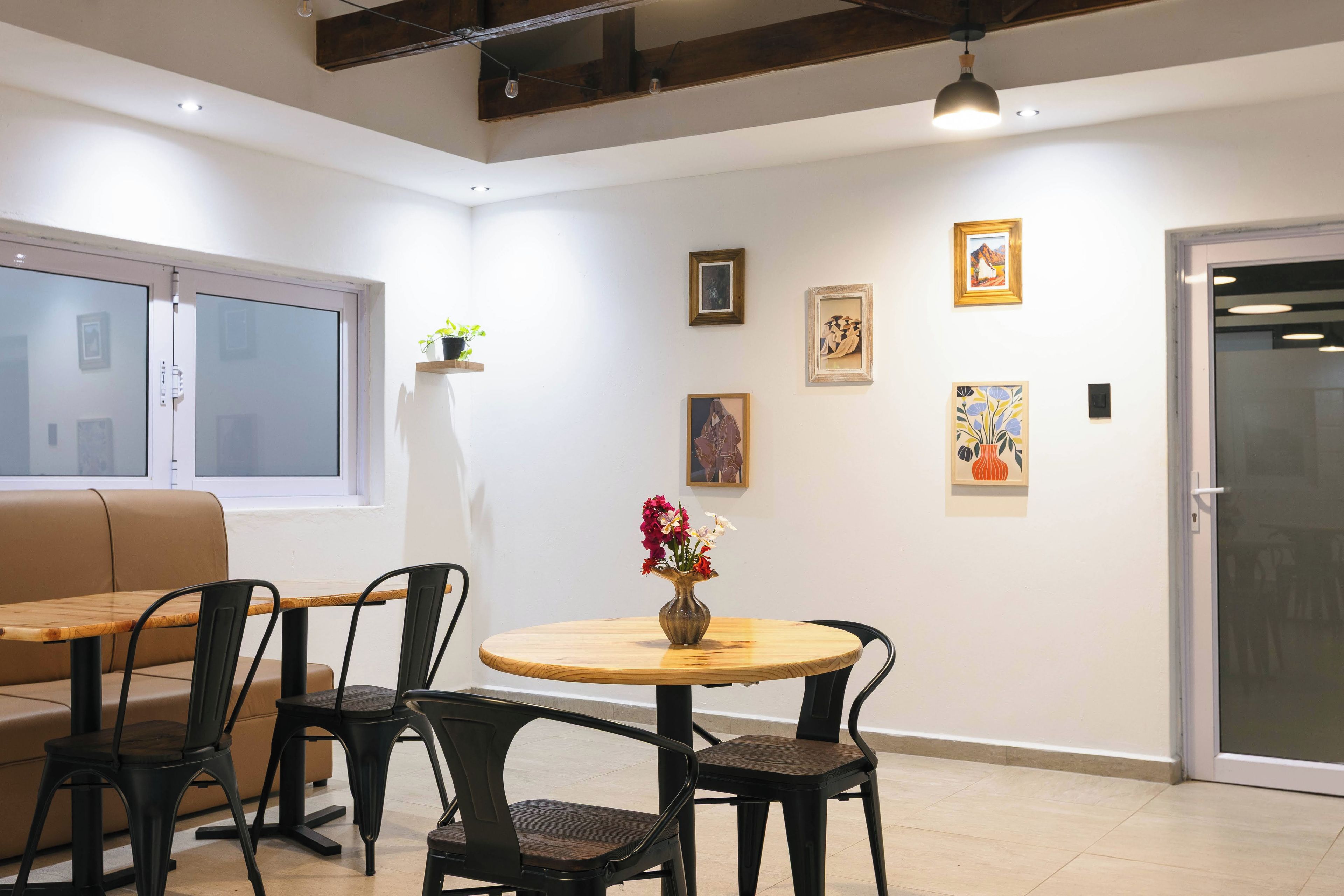 Une pièce avec une table ronde, quatre chaises, un canapé et une fenêtre.