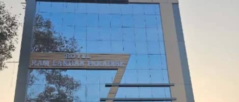 A modern building with a reflective glass facade and a sign that reads 'Hotel'.