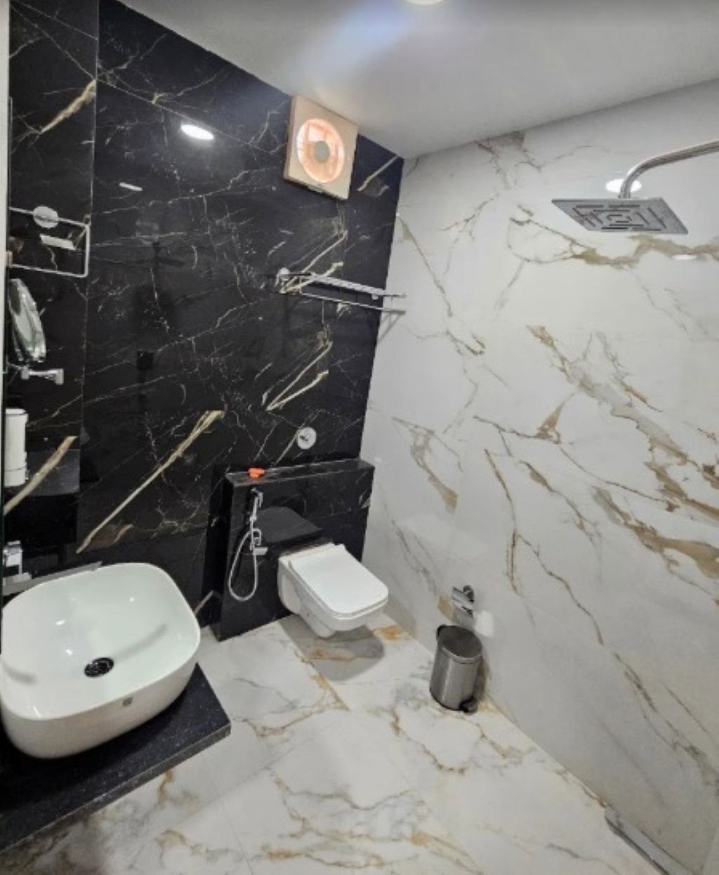Une salle de bain avec un lavabo blanc, des toilettes et une douche.