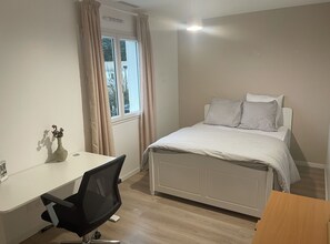 Ein Schlafzimmer mit einem Bett, einem Schreibtisch und einem Stuhl.