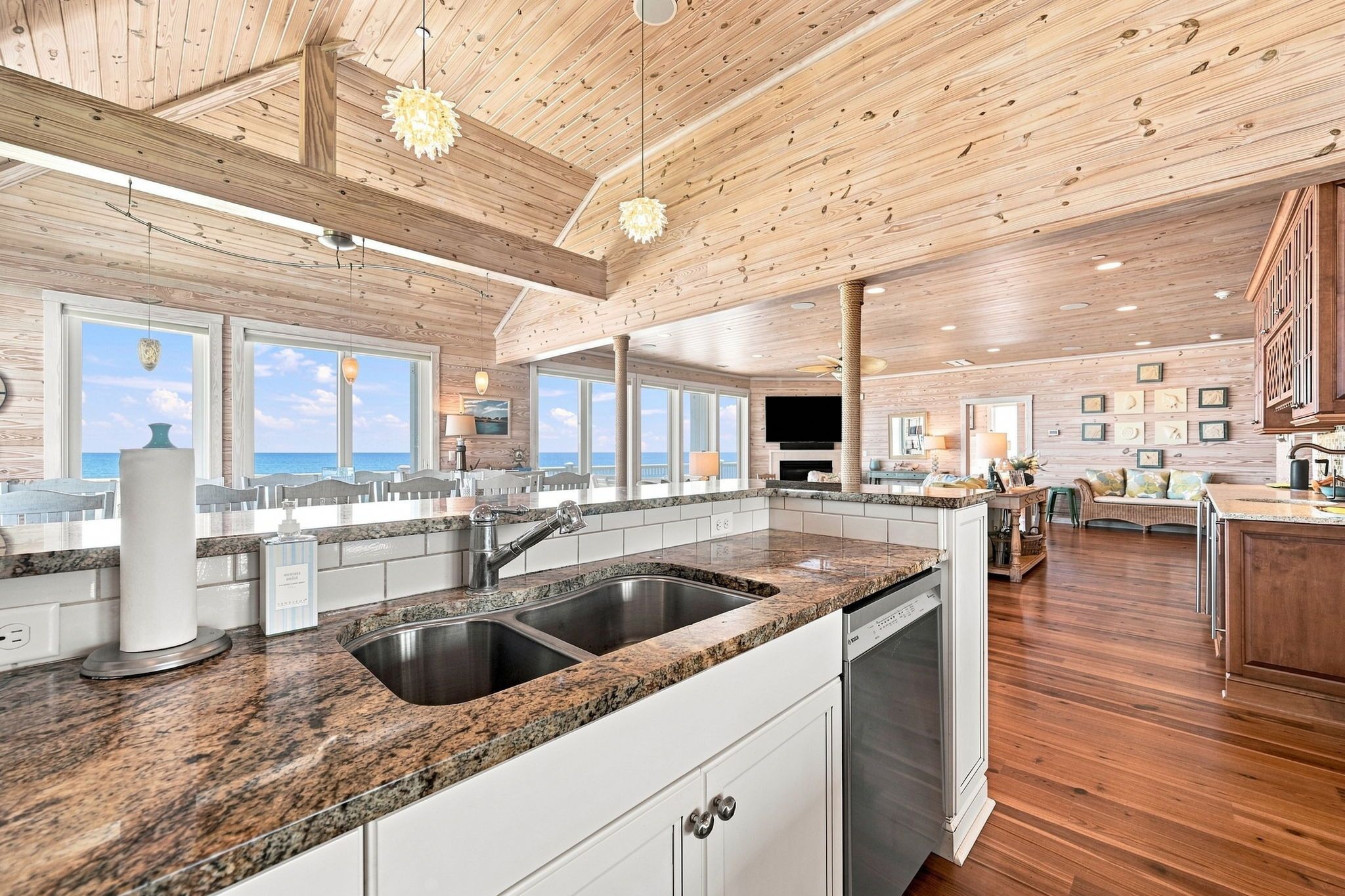 A spacious kitchen with granite countertops, stainless steel appliances, and wooden flooring.